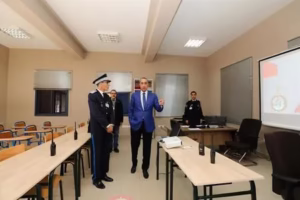 ويأتي افتتاح المدرسة الجديدة لتكوين حراس الأمن بمدينة مراكش، في سياق تنزيل المشاريع البنيوية التي أعلنت عنها المديرية العامة للأمن الوطني مؤخرا ضمن برنامجها السنوي، والمرتبطة بتأهيل وتطوير المرافق الشرطية، بما فيها تعزيز بنيات التكوين الشرطي ودعم الأقطاب الجهوية لمدارس التدريب الأمني.